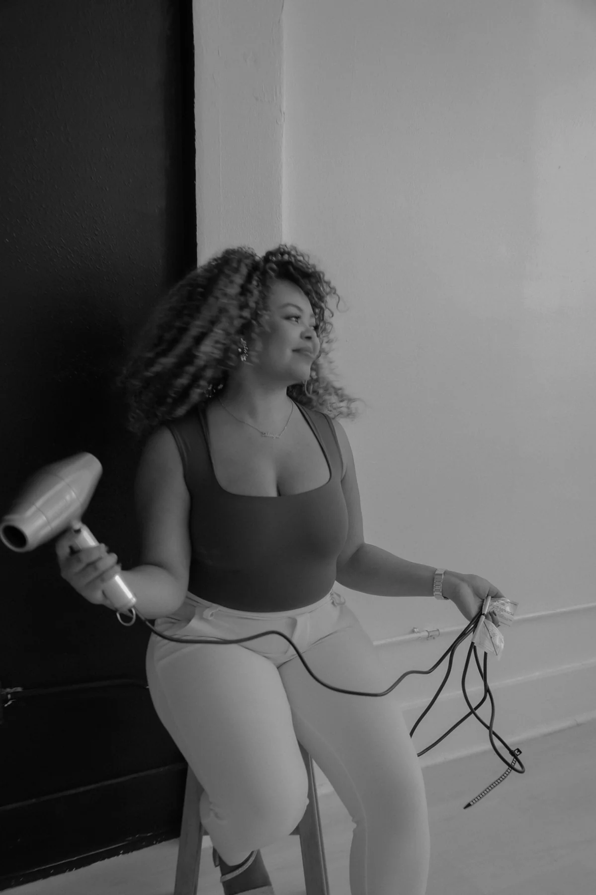 Arien, the stylist behind The Afterglow Curl Studio, in a black-and-white portrait