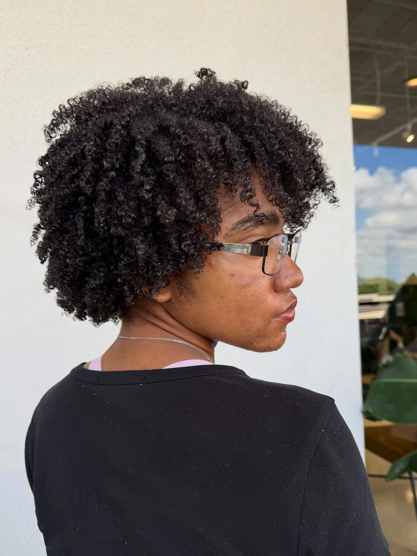 Side-profile view of a rounded Afro haircut styled by Arien